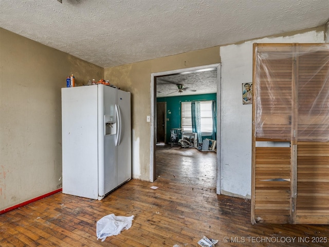 kitchen featuring wood-type flooring, white refrigerator with ice dispenser, ceiling fan, and a textured ceiling