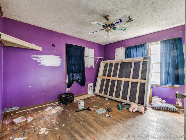 unfurnished bedroom featuring a textured ceiling, hardwood / wood-style floors, and a ceiling fan