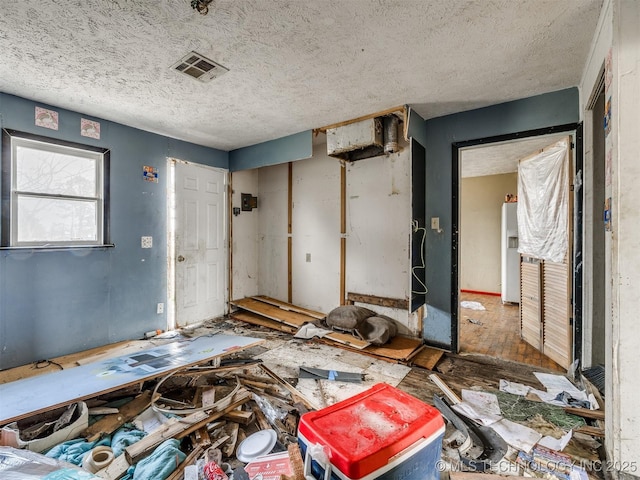 misc room featuring visible vents and a textured ceiling