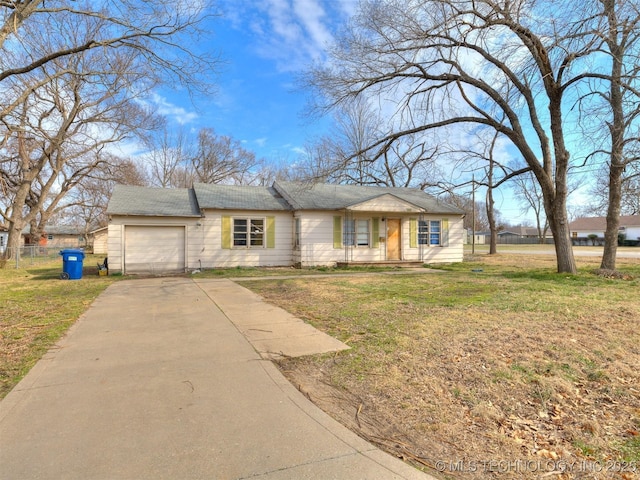 view of front of property with driveway, an attached garage, fence, and a front yard