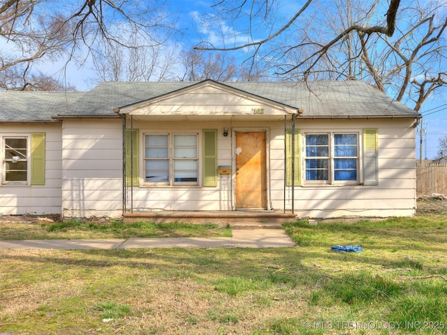 bungalow-style home with a shingled roof and a front yard