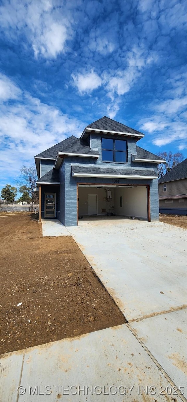 view of front of home featuring a garage, concrete driveway, brick siding, and roof with shingles