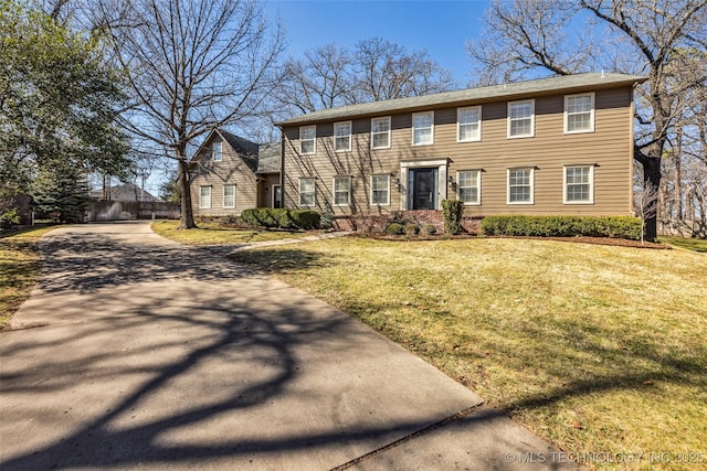 colonial house with driveway and a front lawn