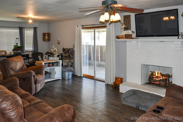 living area featuring a fireplace, visible vents, and wood finished floors