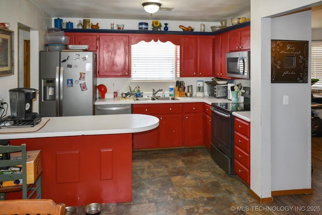 kitchen with reddish brown cabinets, visible vents, stainless steel appliances, light countertops, and a sink