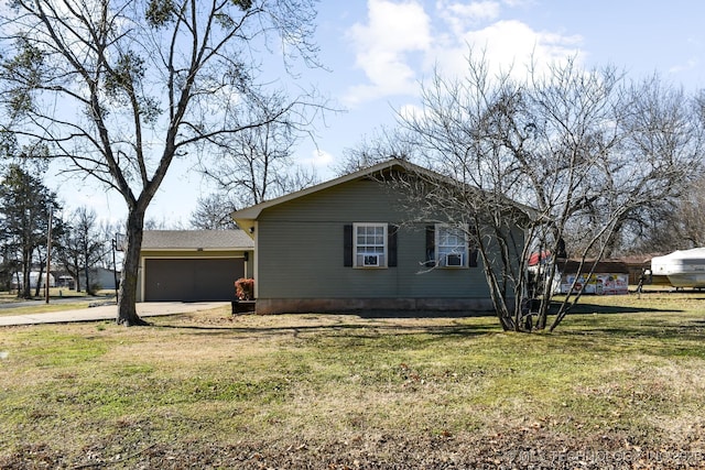 view of side of home featuring a garage, a yard, and driveway