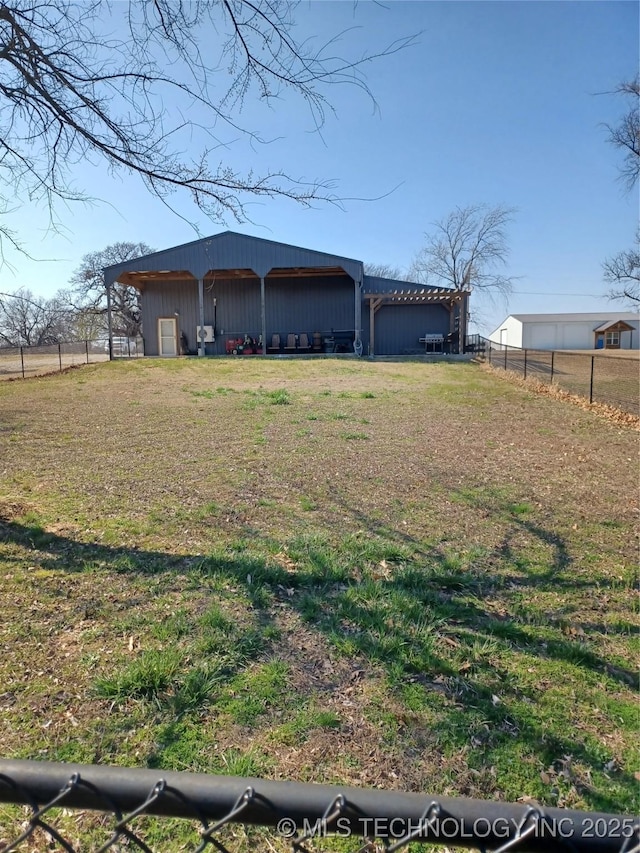 view of home's exterior featuring a yard, fence, an outdoor structure, and an outbuilding