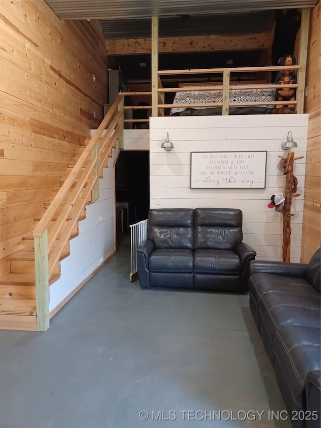 116965 S 4164, Eufaula, OK 74432 - unfurnished living room featuring stairs, wooden walls, and finished concrete floors
