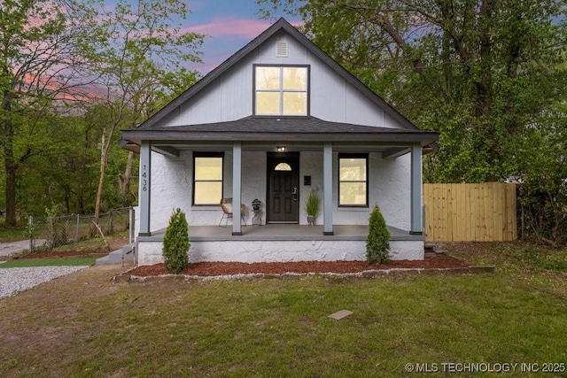 view of front of home featuring a front lawn, fence, and a porch