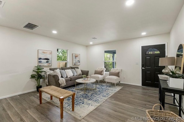 living area with baseboards, visible vents, wood finished floors, and recessed lighting