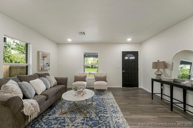 living area with baseboards, visible vents, wood finished floors, and recessed lighting