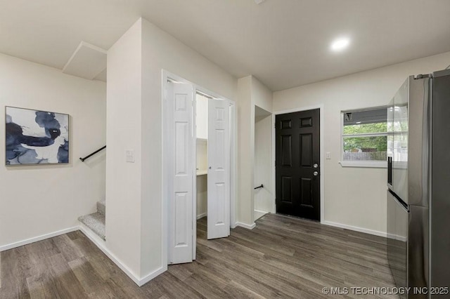 entryway featuring dark wood finished floors, baseboards, and stairs