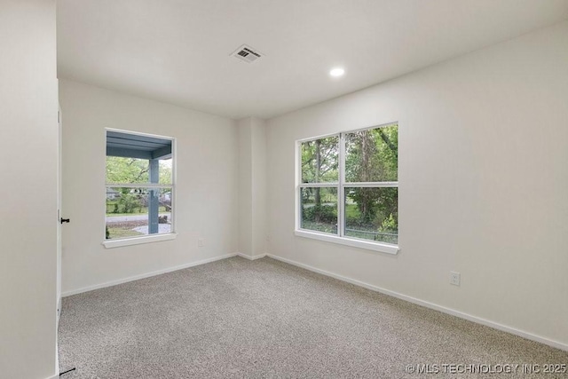 empty room with carpet floors, baseboards, visible vents, and recessed lighting