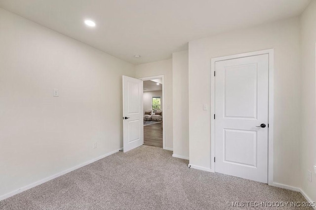 unfurnished bedroom featuring recessed lighting, carpet, and baseboards