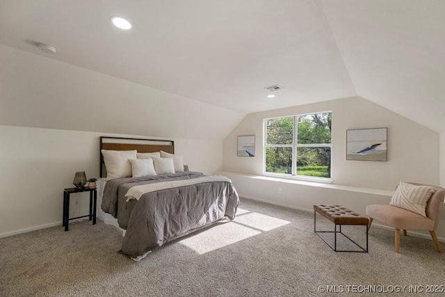 carpeted bedroom with visible vents, vaulted ceiling, and baseboards