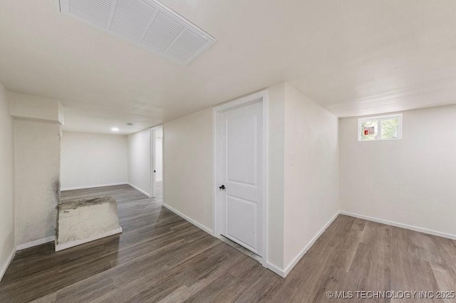 below grade area featuring wood finished floors, visible vents, and baseboards