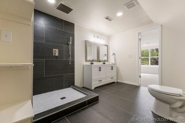 full bath with visible vents, a tile shower, and toilet