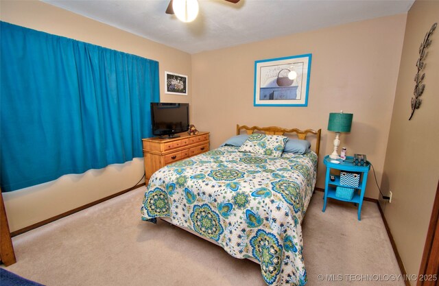 carpeted bedroom with a ceiling fan and baseboards