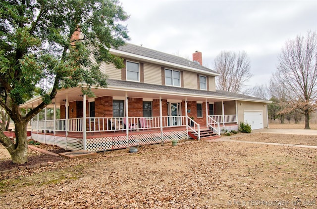 farmhouse inspired home with brick siding, a chimney, a porch, an attached garage, and driveway