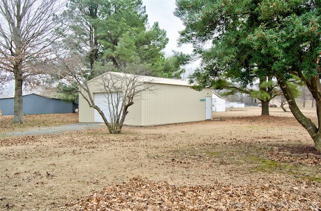 exterior space featuring aphalt driveway, an outbuilding, and a detached garage