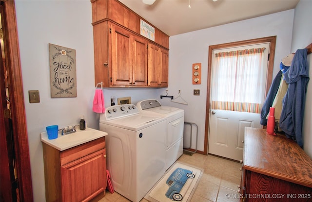 laundry area featuring a sink, light tile patterned floors, washing machine and dryer, and cabinet space