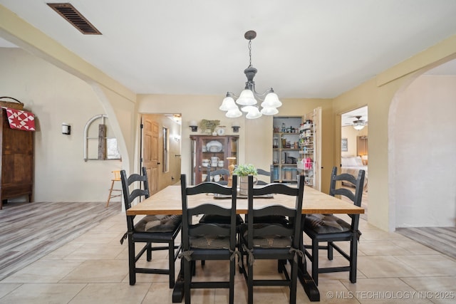 448 Springview Dr, Skiatook, OK 74070 - dining area with arched walkways, a chandelier, light tile patterned floors, and a ceiling fan