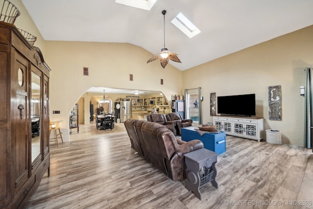 448 Springview Dr, Skiatook, OK 74070 - living area with arched walkways, light wood finished floors, a skylight, high vaulted ceiling, and a ceiling fan