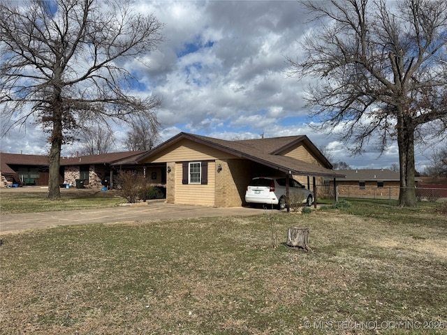 view of side of home featuring a carport, a lawn, driveway, and fence