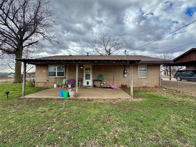 back of house with a patio area, fence, brick siding, and a lawn