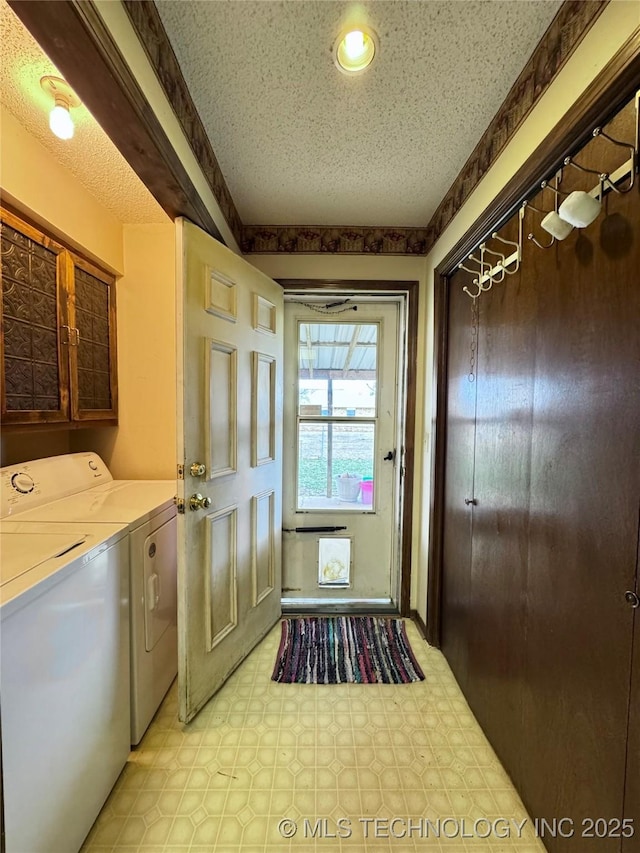 laundry room with a textured ceiling, laundry area, light floors, and washing machine and dryer