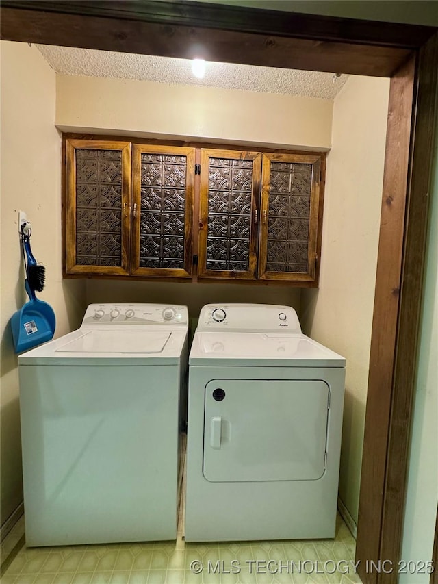 clothes washing area featuring washer and dryer and cabinet space