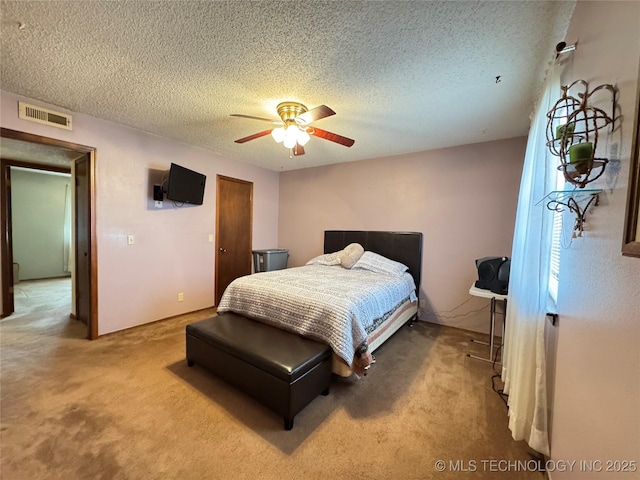 bedroom featuring carpet floors, a ceiling fan, visible vents, and a textured ceiling