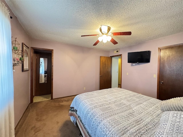 carpeted bedroom featuring ceiling fan and a textured ceiling