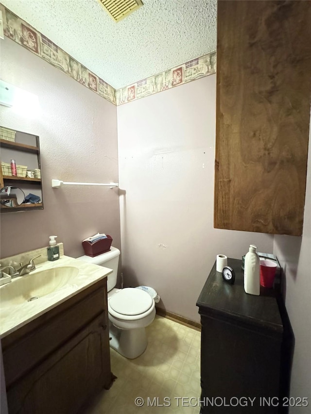 half bathroom with visible vents, vanity, toilet, and tile patterned floors