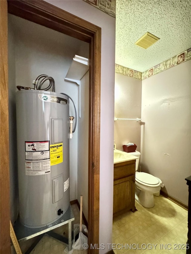 half bath with toilet, electric water heater, visible vents, vanity, and tile patterned floors