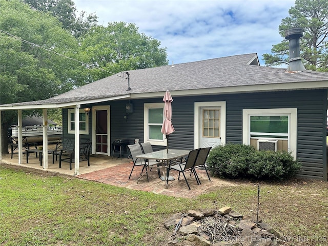 back of house featuring a patio, a yard, and roof with shingles