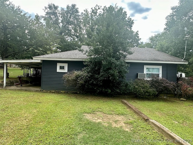 exterior space featuring an attached carport, a lawn, and roof with shingles