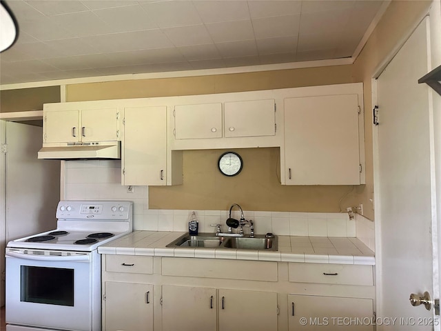 kitchen featuring under cabinet range hood, a sink, tile counters, white range with electric stovetop, and tasteful backsplash