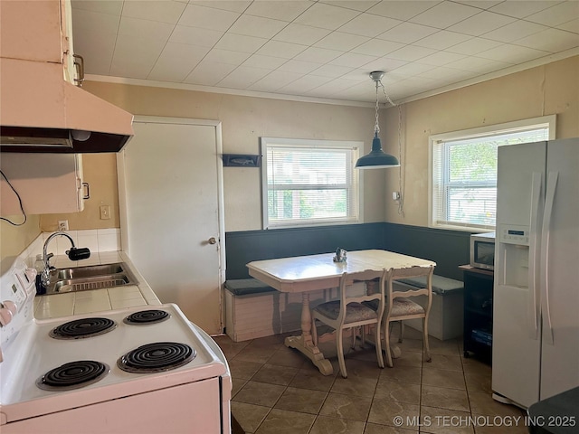 kitchen featuring breakfast area, ornamental molding, a sink, white appliances, and tile patterned floors