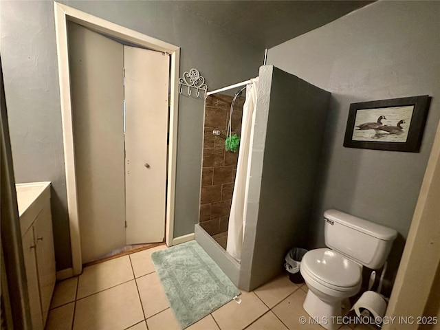 full bathroom featuring vanity, a shower stall, toilet, and tile patterned floors