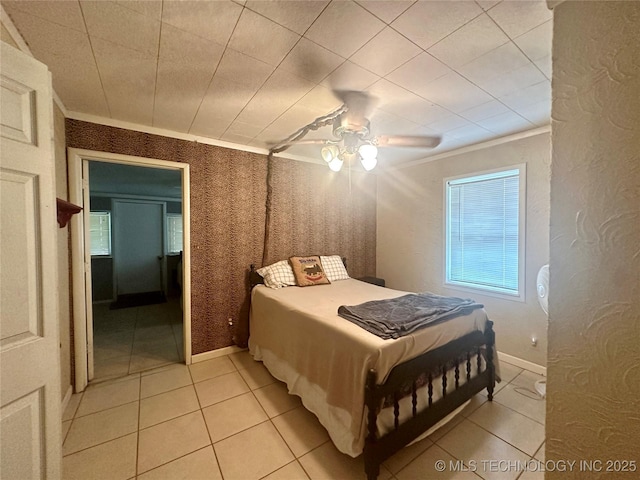 bedroom featuring ceiling fan, ornamental molding, light tile patterned flooring, and baseboards