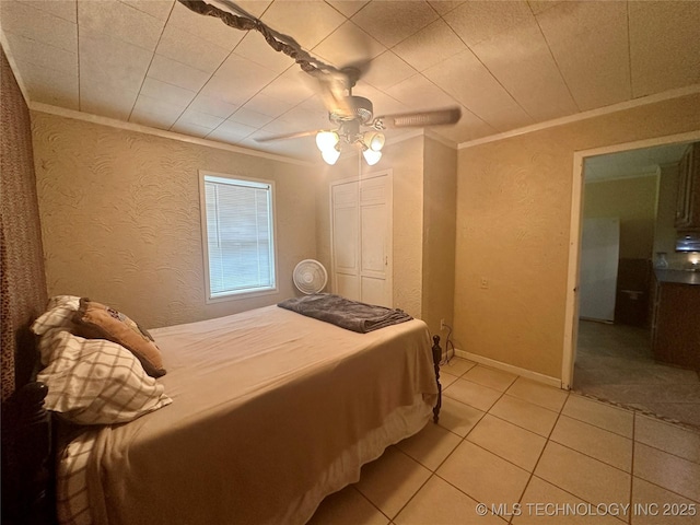 bedroom with light tile patterned floors, baseboards, a textured wall, ceiling fan, and crown molding