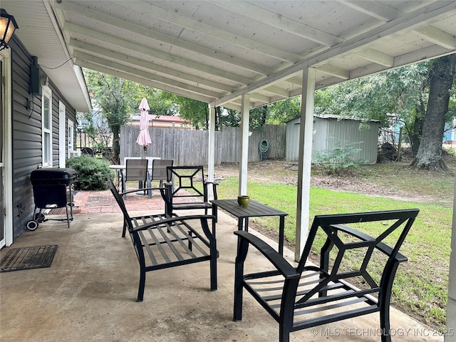 view of patio with outdoor dining area, a storage unit, grilling area, fence, and an outdoor structure