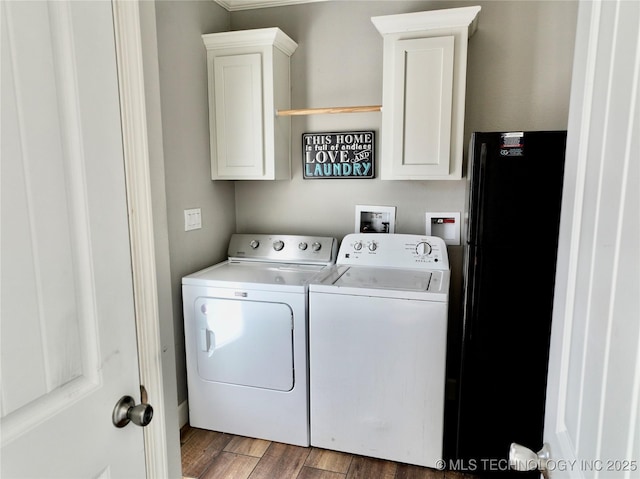 laundry room featuring independent washer and dryer, wood finished floors, and cabinet space