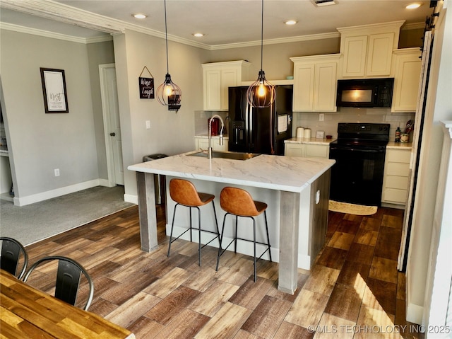 kitchen featuring a breakfast bar, a sink, black appliances, tasteful backsplash, and dark wood finished floors