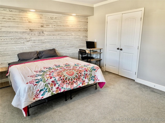 carpeted bedroom featuring ornamental molding, a closet, wood walls, and baseboards