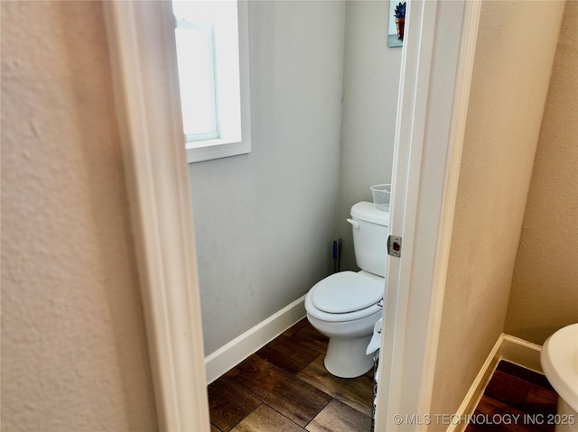 bathroom featuring baseboards, toilet, and wood finished floors