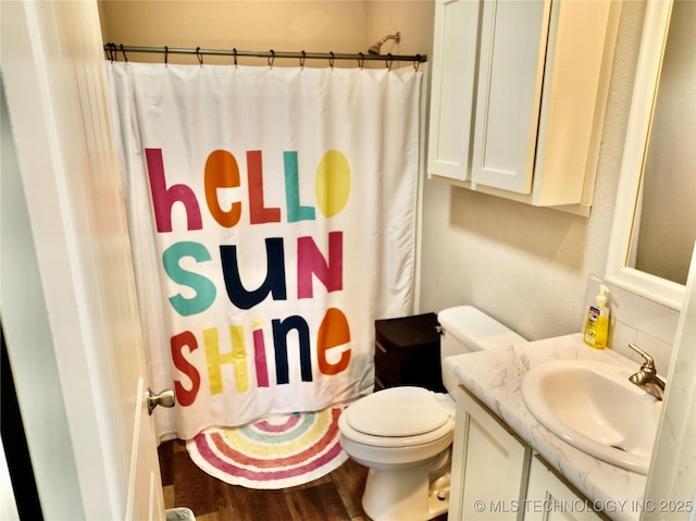 full bath featuring toilet, a shower with curtain, wood finished floors, and vanity