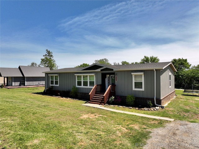 view of front facade with a front lawn and board and batten siding