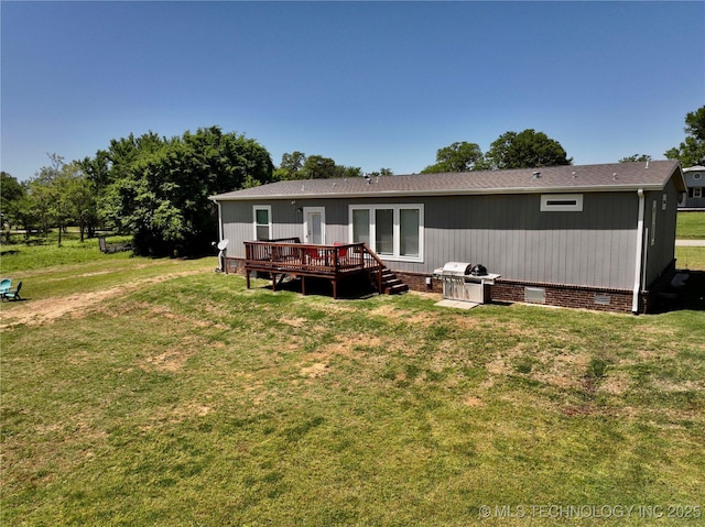 rear view of property with crawl space, a wooden deck, and a lawn